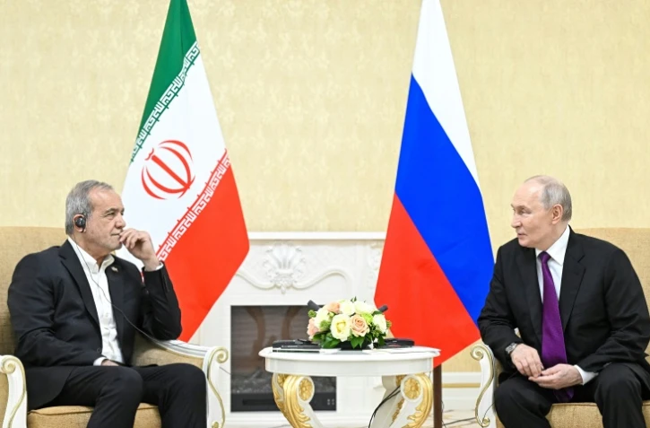 Le président russe Vladimir Poutine (droite) et son homologue iranien Masoud Pezeshkian s'entretiennent, le 8 octobre 2026 à Turkmenbashi au Turkménistan, sur cette photo distribuée par l'agence russe Spoutnik