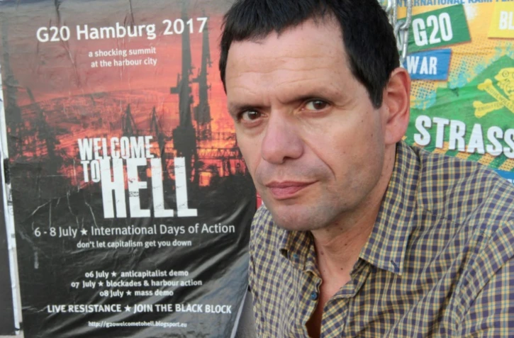 Andreas Blechschmidt, l'un des plus anciens activistes du "Rote Flora", devant une affiche "Bienvenue en Enfer", le 19 juin 2017 à Hambourg où se tiendra le sommet du G20 