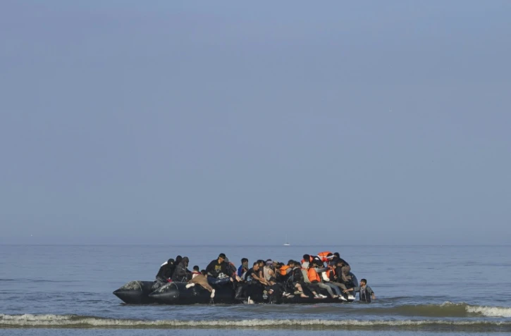 Des migrants tentent de monter à bord d'un bateau de passeurs pour traverser la Manche au large de la plage d'Equihen, dans le nord de la France, le 30 juin 2025