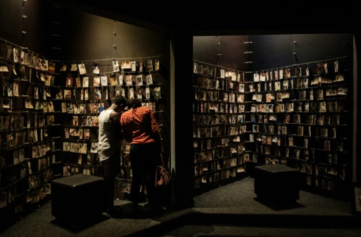 Des visiteurs regardent des  portraits de victimes du génocide de 1994 au Rwanda, exposés au Mémorial du génocide à Kigali, le 29 avril 2018