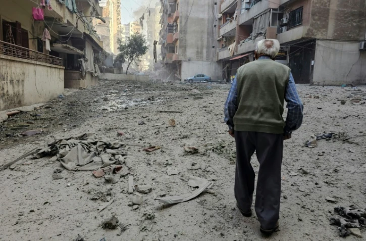 Un vieil homme marche au milieu des destructions provoquées opar des frappes israéliennes dans le quartier de Rweiss dans la banlieue sud de Beyrouth, le 14 novembre 2024