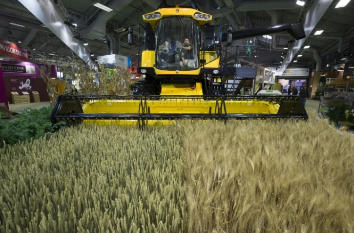 Un homme nettoie le pare-brise à l'intérieur d'une moissonneuse-batteuse au Salon de l'Agriculture à Paris le 24 février 2017