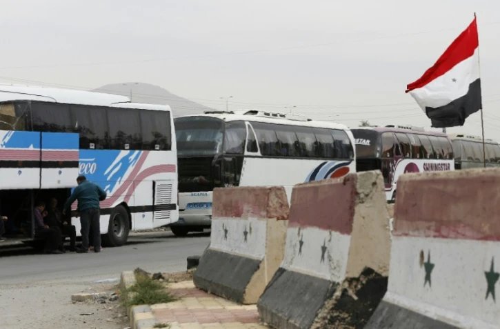 Bus du gouvernement syrien stationnés au passage de Wafidine, en périphérie de Damas, dans l'attente de nouvelles évacuations de Douma des combattants rebelles et de leus famille, le 3 avril 2018