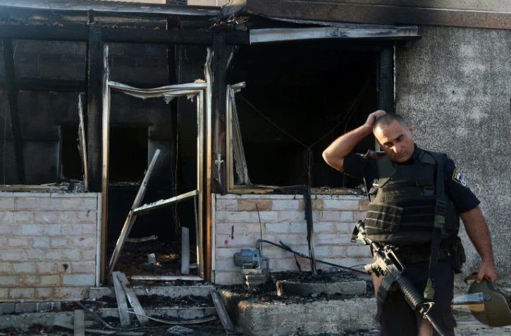 Un membre des forces de sécurité israélienne inspecte une maison incendiée par des juifs extrémistes dans le village de Duma en Cisjordanie, le 31 juillet 2015