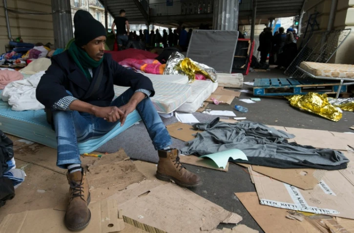 Un migrant assis sur un matelas dans un camp sous la station de métro Stalingrad à Paris le 24 mars 2016