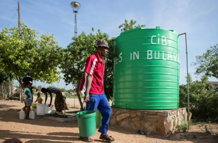 Un homme transportant un seau d'eau en périphérie de Bulawayo le 24 novembre 2016