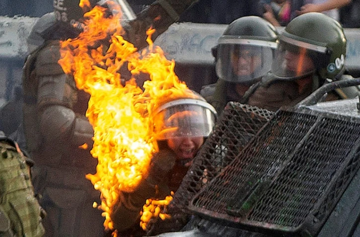 Une policière atteinte par un cocktail molotov pendant une manifestation à Santiago du Chili, le 4 novembre 2019