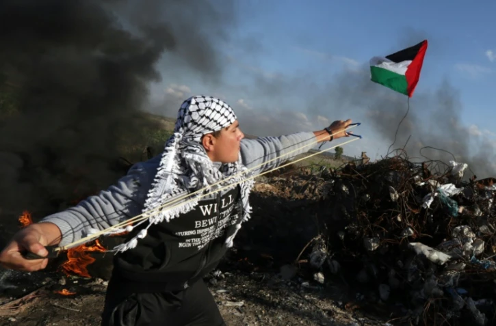 Un militant palestinien affronte les forces de sécurité israéliennes le 18 décembre 2015 sur la frontière entre Israël et la bande de Gaza 