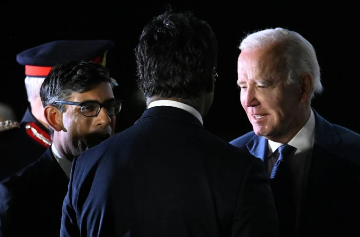 Le président américain Joe Biden (d) accueilli par le Premier ministre britannique Rishi Sunak (g) à son arrivée à l'aéroport de Belfast, le 11 avril 2023 en Irlande du Nord