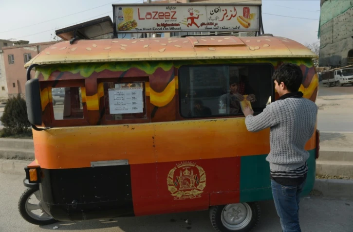 Un client afghan achète un burger dans un "food truck" à Kaboul, le 27 décembre 2015