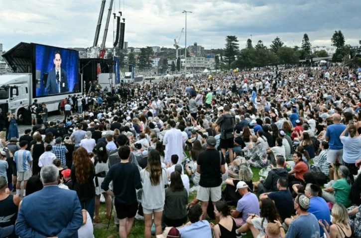 Des personnes assistent à la cérémonie en hommage aux victimes de la tuerie antisémite de Bondi Beach, à Sydney, le 21 décembre 2025