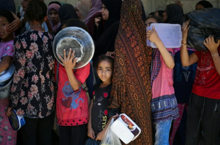 Des enfants attendent dans un centre de distribution d'aide humanitaire à Nousseirat, dans le centre de la bande de Gaza, le 2 juin 2025
