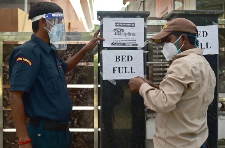 Un agent de sécurité affiche un message prévenant que plus aucun lit n'est disponible, dans un h?'pital privé d'Allahabad (Inde) le 22 avril 2021