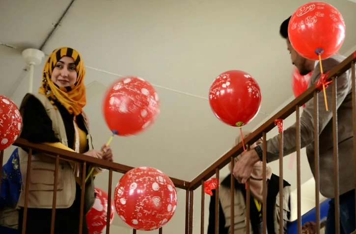 Une membre de l'association Génération Renaissance distribue des ballons pour la Saint-Valentin dans une école à Mossoul le 14 février 2017