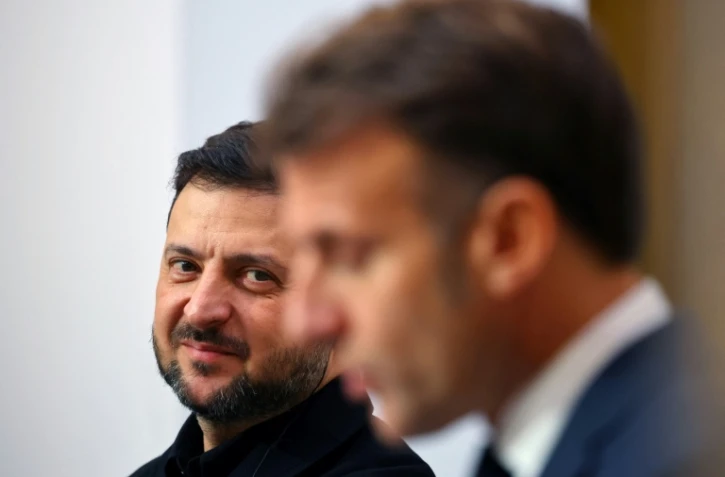 Le président ukrainien Volodymyr Zelensky écoute son homologue français Emmanuel Macron lors d'une conférence de presse, le 17 novembre 2025 à Paris
