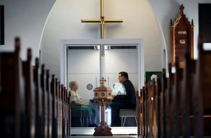 Le pasteur Joel Crouse (D) échange avec une fidèle à l'église luthérienne Saint John d'Ottawa, le 16 septembre 2020