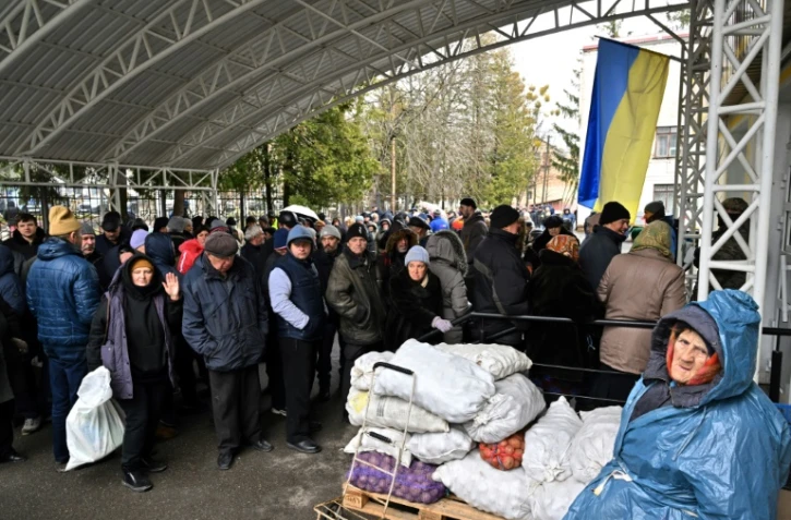 Des habitants font la queue pour s'approvisionner en nourriture et en médicaments, à Boutcha, près de Kiev, le 3 avril 2022