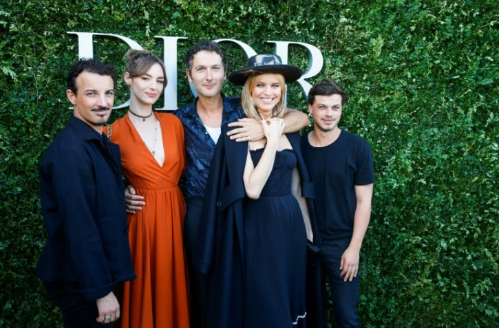 Simon Buret (C), chanteur du groupe AaRON, l'actrice Louise Bourgoin (2eG) et le mannequin Eva Herzigova (2eD) posent à l'occasion de l'exposition célébrant le 70e anniversaire de la maison Dior au Musée des Arts Décoratifs à Paris, le 3 juillet 2017