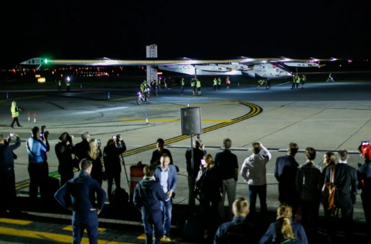 Des spectateurs regardent l'arrivée de Solar Impulse 2 après son atterrissage à l'aéroport JFK International à New York, le 11 juin 2016 