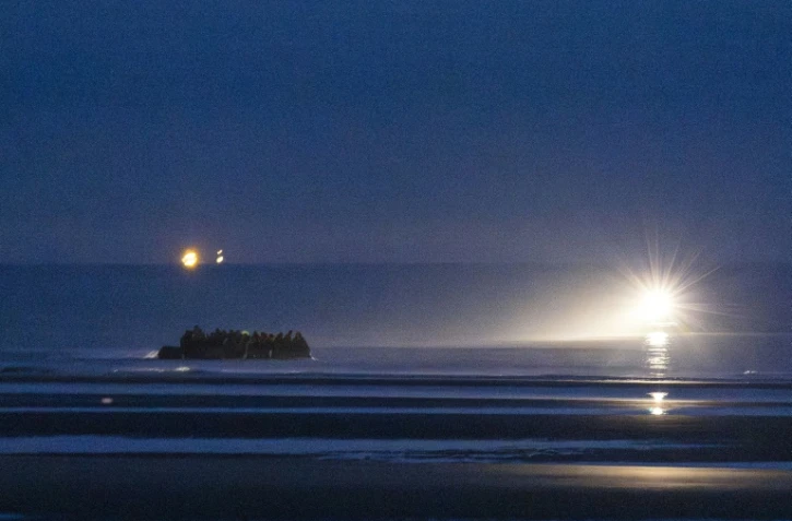 Des migrants embarquent à bord d'un bateau pour tenter une traversée de la Manche le 19 septembre 2025 au large de la plage de Gravelines