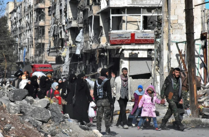 Des Syriens retournent chez eux dans un district repris par les forces gouvernementales à Alep, le 8 décembre 2016