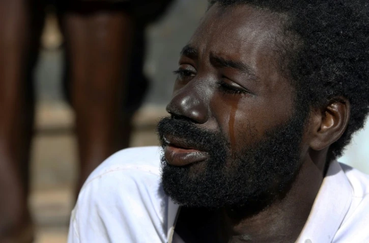 Amara, un migrant du Mali pleure en racontant son histoire dans un foyer de fortune dans la ville de Bani Walid en Libye, le décembre 2017