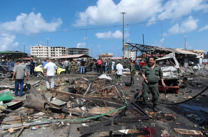Des Syriens sur le site de plusieurs bombardements Ă Jableh le 23 mai 2016