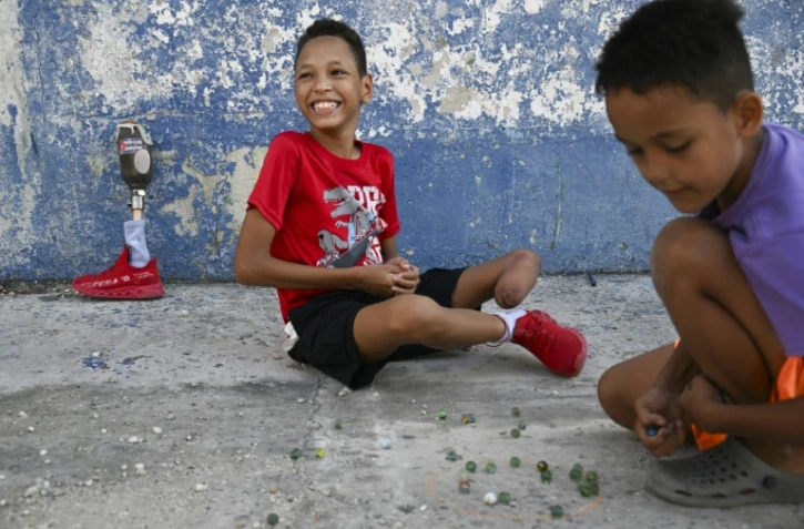 Juan Jose Guilarte, 10 ans, joue aux billes avec un camarade à La Havane, le 25 avril 2026 à Cuba
