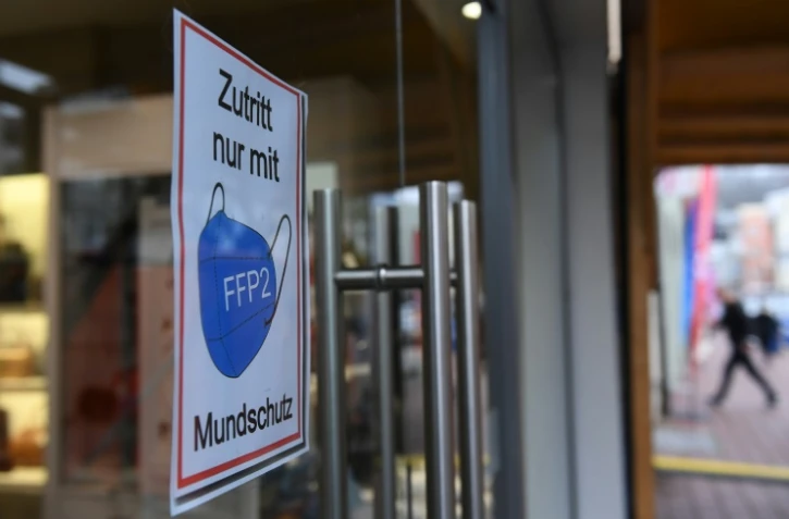 Une affiche rappelant de porter un masque de protection à l'entrée d'une boutique, le 24 novembre 2021 à Muhldorf am Inn, en Allemagne