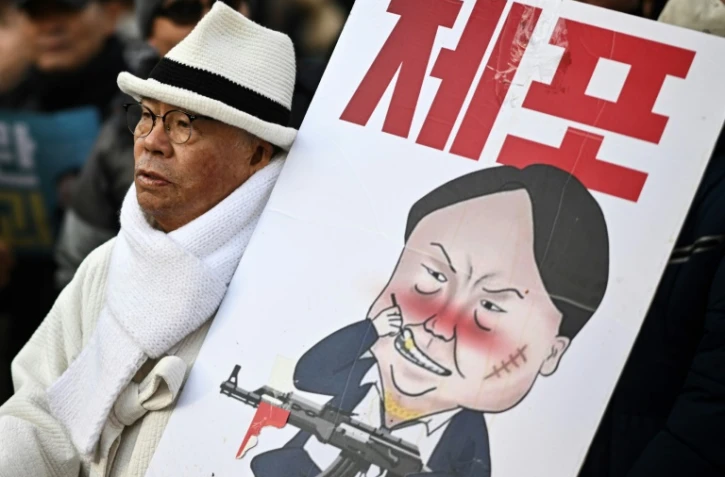 Un manifestant brandit une caricature du président sud-coréen déchu Yoon Suk Yeol, le 3 janvier 2024 à Séoul
