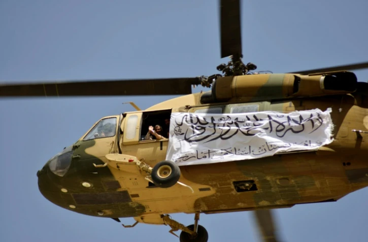 Un drapeau taliban est transporté comme un étendard dans le ciel lors de son survol au-dessus de Kandahar, le 1er septembre 2021 pour célébrer le départ des forces militaires étrangères 