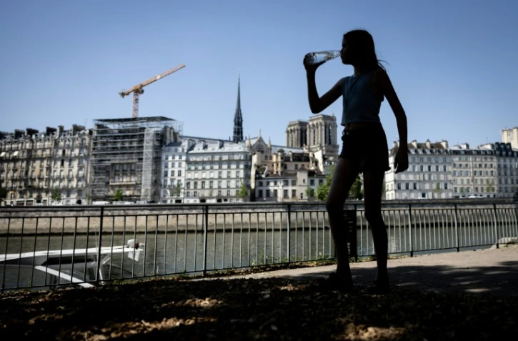 Une jeune femme s'hydrate pendant la canicule, le 24 juin 2026 Ă Paris