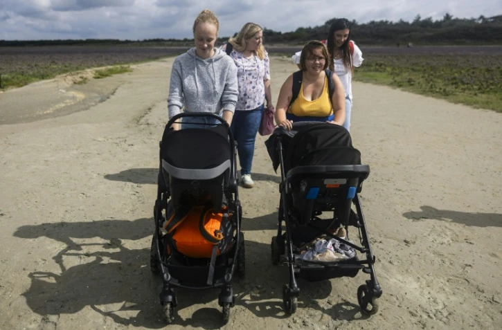 Anne-Marie Seye (à droite), 16 ans, mère d'un bébé de 6 mois, se promène avec Lou-Anne Begue, 17 ans, et son bébé de 11 mois, dans la réserve naturelle de la baie de Somme, le 30 juillet 2025