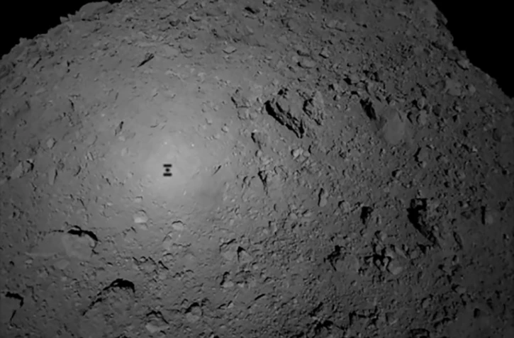 Photo fournie par l'Agence spatiale nippone Jaxa le 3 octobre 2018 montrant l'ombre de la sonde japonaise Hayabusa2 au-dessus de l'astéroïde Ryugu