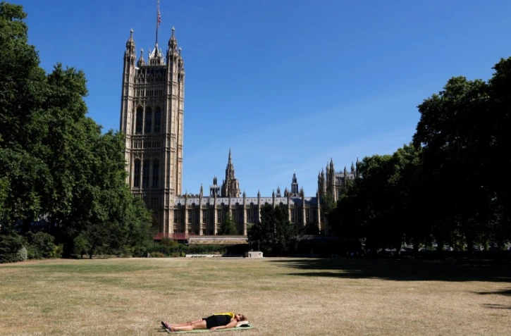Une femme au soleil devant Westminster à Londres le 11 juillet 2022