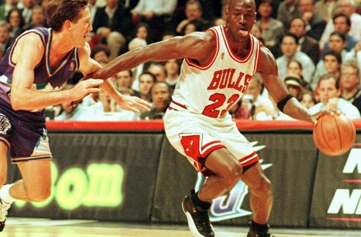 Michael Jordan dans son attitude caractéristique, toute langue dehors, sous le maillot des Chicago Bulls en un contre-un devant Jeff Hornacek des Utah Jazz en finale NBA le 4 jui 1997 à Chicago