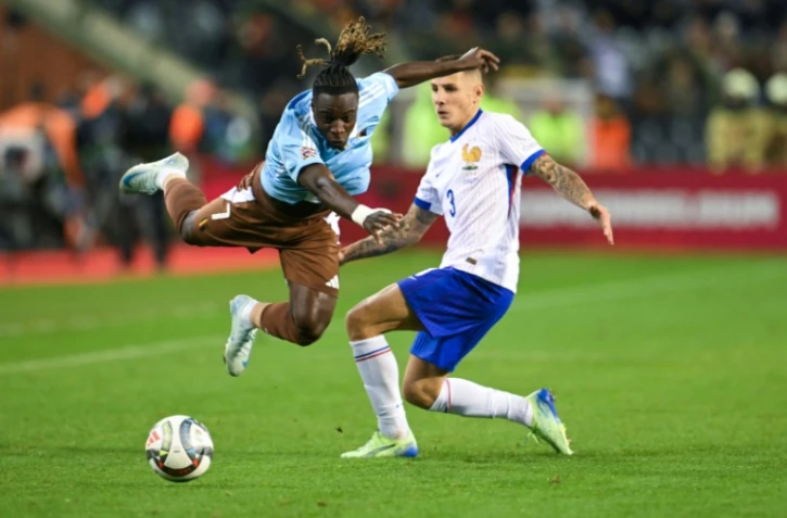 Le défenseur de l'équipe de France Lucas Digne tente de s'interposer devant l'attaquant belge Jeremy Doku en Ligue des nations le 14 octobre 2024 au stade Roi Baudoin à Bruxelles