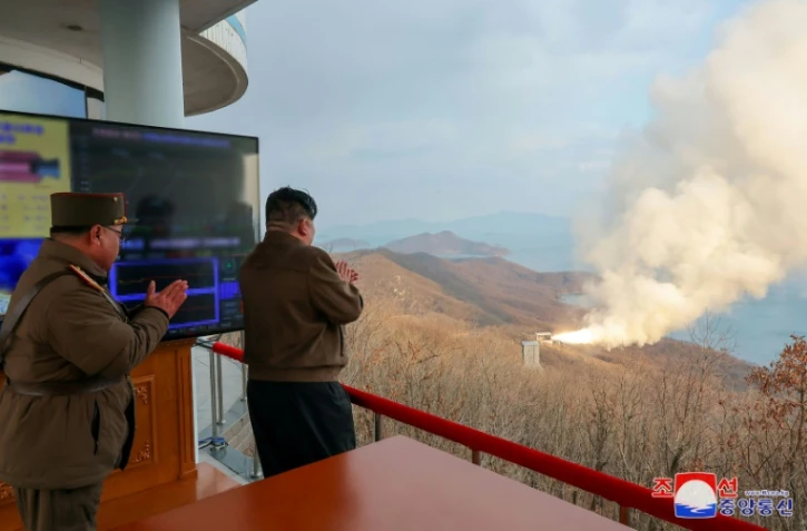 Photo diffusée le 20 mars 2024 par l'agence nord-coréenne Kcna du dirigeant nord-coréen Kim Jong Un (d) supervisant l'essai d'un moteur à combustible solide pour un "nouveau type de missile hypersonique de portée intermédiaire" sur le site de lancement de Sohae, le 19 mars 2024 dans le nord-ouest du pays