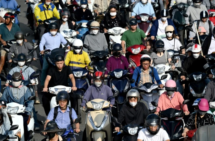 Des conducteurs de deux-roues dans une rue de Hanoi, le 17 juillet 2025 