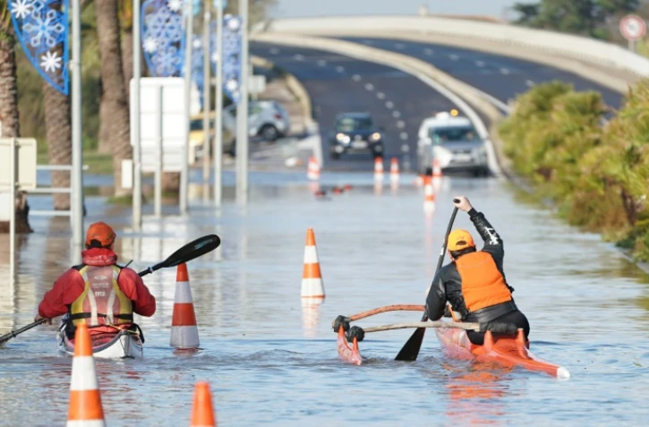 Deux hommes se déplacent en kayak sur une route inondée à Palavas-les-Flots le 23 novembre 2019