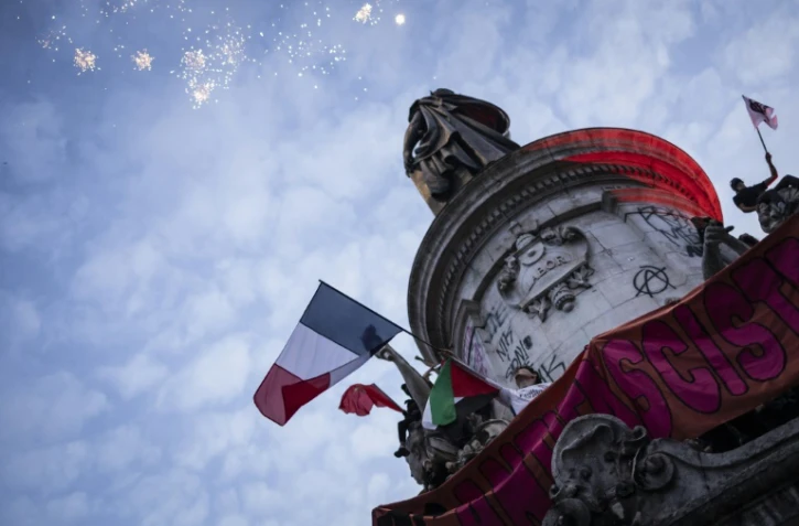 Une foule célèbre l'arrivée en tête surprise du Nouveau Front Populaire (NFP) au second tour des élections législatives, le 7 juillet 2024 place de la République à Paris 
