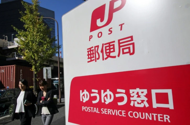 Des Japonaises marchent à côté d'un bureau de poste à Tokyo, le 26 octobre 2015