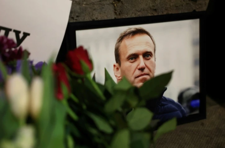Des photos et des fleurs sont déposées en hommage à Alexeï Navalny devant l'ambassade russe au Royaume-Uni, le 16 février 2024 à Londres