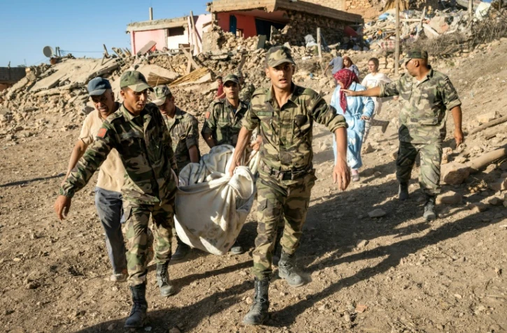 Des soldats marocains évacuent un corps dans le village de Tafeghaghte, détruit par un séisme, le 9 septembre 2023