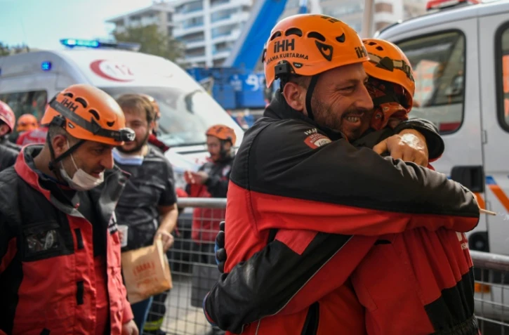 Deux secouristes turcs, Ahmet Celik (D) et Ibrahim Topal (2èG), s'étreignent après avoir sauvé une fillette de trois ans, Ayda Gezgin, des décombres le 3 novembre 2020