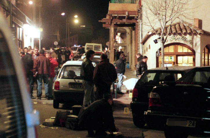 Photo datée du 6 février 1998 de policiers sur le lieu où se trouve le corps du préfet de Corse Claude Erignac, assassiné par trois balles dans la tête alors qu'il se rendait à un concert dans le centre-ville d'Ajaccio