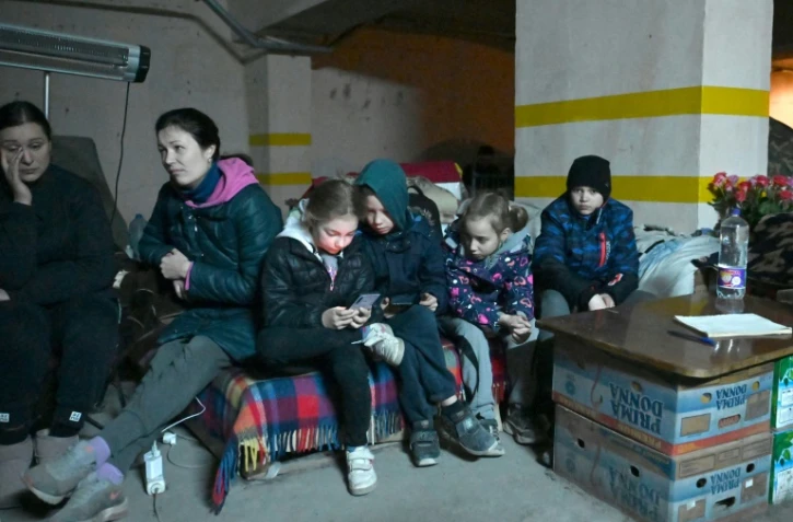 Des enfants et leurs familles Ă l'abri des bombes dans un parking souterrain, le 23 avril 2022 Ă Kharkiv