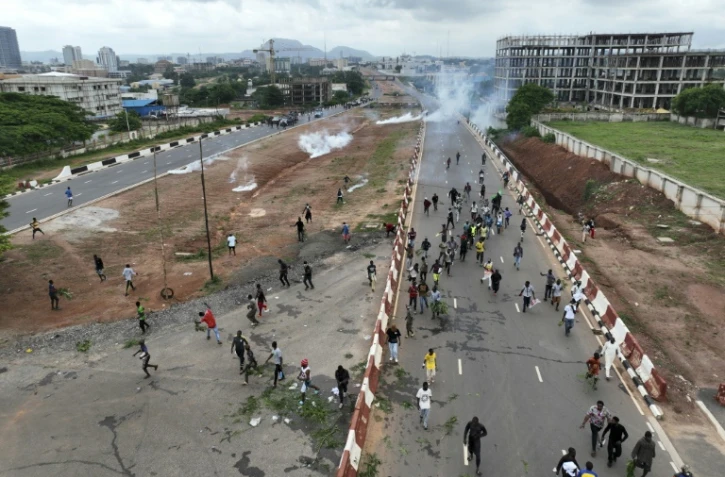 Vue aérienne de manifestants contre la vie chère à Abuja au Nigeria, le 2 août 2024, fuyant des tirs de gaz lacrymogène