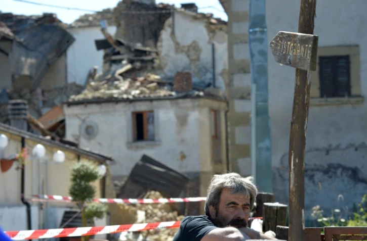 Un homme au milieu des décombres le 29 août 2016 dans le hameau de Torrita près d'Amatrice en Italie