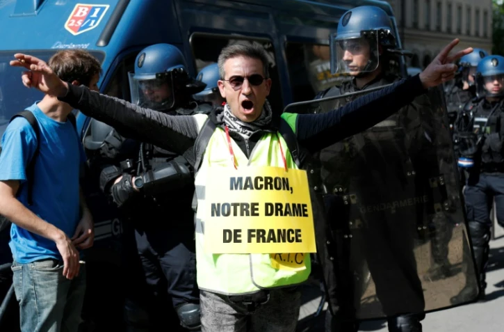 Un militant porte une pancarte avec l'inscription "Macron, notre drame français" en référence à l'incendie qui a dévasté Notre-Dame de Paris, le 20 avril 2019